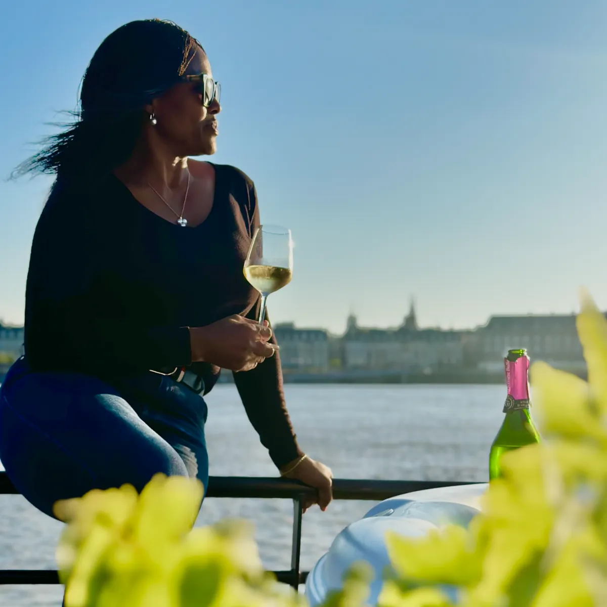 femme tenant un verre de vin lors d'une croisière fluviale à Bordeaux